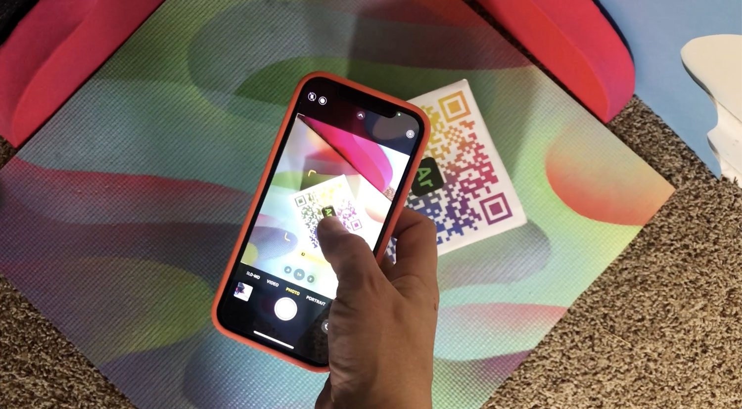 The All Seeing Die — hand holding the physical QR code gameboard for AR activation